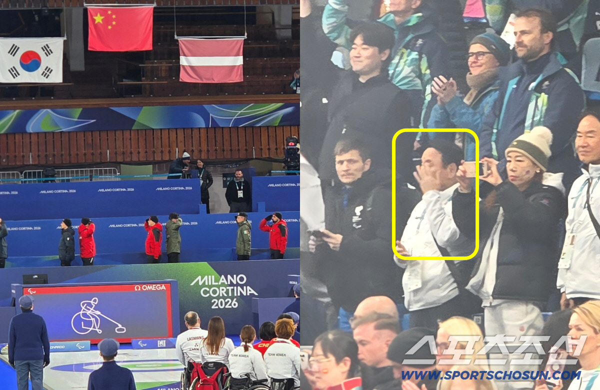 16년만의 메달, 4년의 분투가 은메달의 결실로 이어지는 순간. 밀라노-코르티나 동계패럴림픽 메달 시상식 태극기가 올라가는 모습을 지켜보던 관중석의 윤경선 대한장애인컬링협회장이 눈물을 훔치고 있다.