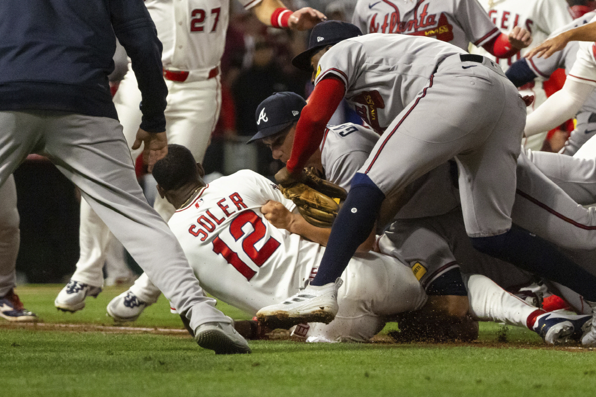 Los Angeles Angels' Jorge Soler (12) is tackled to the ground by Atlanta Braves players as a fight breaks out during the fifth inning of a baseball game, Tuesday, April 7, 2026, in Anaheim, Calif. (AP Photo/Ethan Swope)