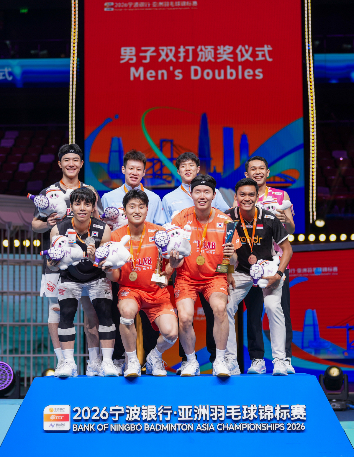 (260412) -- NINGBO, April 12, 2026 (Xinhua) -- First-placed Kim Won Ho (2nd L bottom)/Seo Seung Jae (2nd R bottom) of South Korea, second-placed Kang Min Hyuk (1st L top)/Ki Dong Ju (1st L bottom) of South Korea, third-placed He Jiting (2nd R top)/Ren Xiangyu (2nd L top) of China and Fajar Alfian (1st R top)/Muhammad Shohibul Fikri of Indonesia pose during the men's doubles awarding ceremony at Badminton Asia Championships 2026 in Ningbo, east China's Zhejiang Province, April 12, 2026. (Xinhua/Sun Fei)
