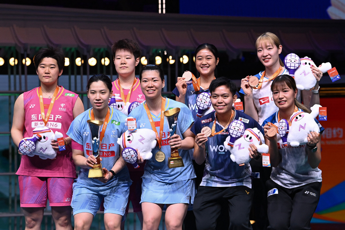 Gold medallists China´s Li Yijing (2/L), Luo Xumin (4/L), silver China´s medallists Liu Shengshu (3/L) and Tan Ning (L), bronze medallists Amallia Cahaya Pratiwi (3/R) and Siti Fadia Silva Ramadhant (R) of Indonesia and Mayu Matsumoto (2/R) and Yuki Fukushima of Japan pose on the podium during the award ceremony for women's doubles final match at the Badminton Asia Championship in Ningbo, eastern China's Zhejiang province on April 12, 2026. (Photo by CN-STR / AFP) / China OUT