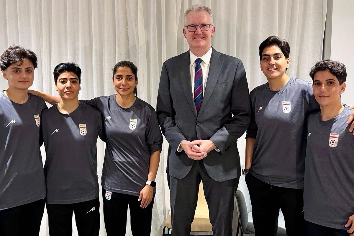 (FILES) An undated and unplaced photo released by Australia's Department of Home Affairs shows Iranian women's football team captain Zahra Ghanbari (2nd R) posing with Australian Home Affairs minister Tony Burke (3rd R) and other members of her team (L to 3rd L, and R) Fatemeh Pasandideh, Mona Hamoudi, Atefeh Ramezanizadeh, and Zahra Sarbali, who applied for asylum after competing in the Women's Asia Cup tournament being played in Australia. Iranian women's football team captain Zahra Ghanbari had withdrawn her Australia asylum bid, Iran state media said on March 15, 2026. (Photo by Handout / AUSTRALIAN DEPARTMENT OF HOME AFFAIRS / AFP) / ----EDITORS NOTE ----RESTRICTED TO EDITORIAL USE MANDATORY CREDIT " AFP PHOTO / DEPARTMENT OF HOME AFFAIRS" NO MARKETING NO ADVERTISING CAMPAIGNS - DISTRIBUTED AS A SERVICE TO CLIENTS