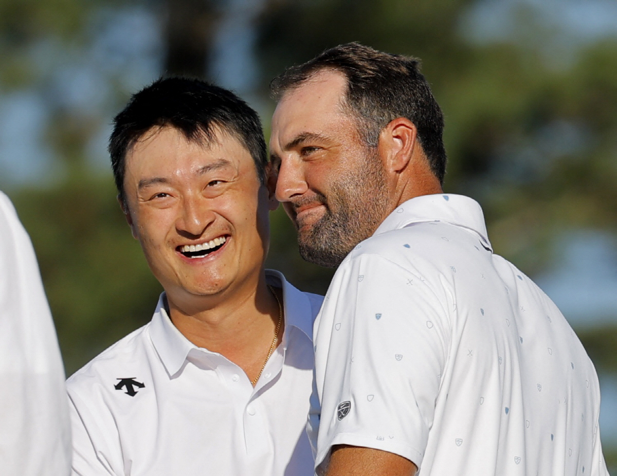 Golf - The Masters - Augusta National Golf Club, Augusta, Georgia, U.S. - April 12, 2026 China's Haotong Li and Scottie Scheffler of the U.S. on the 18th hole after finishing their final round REUTERS/Mike Blake