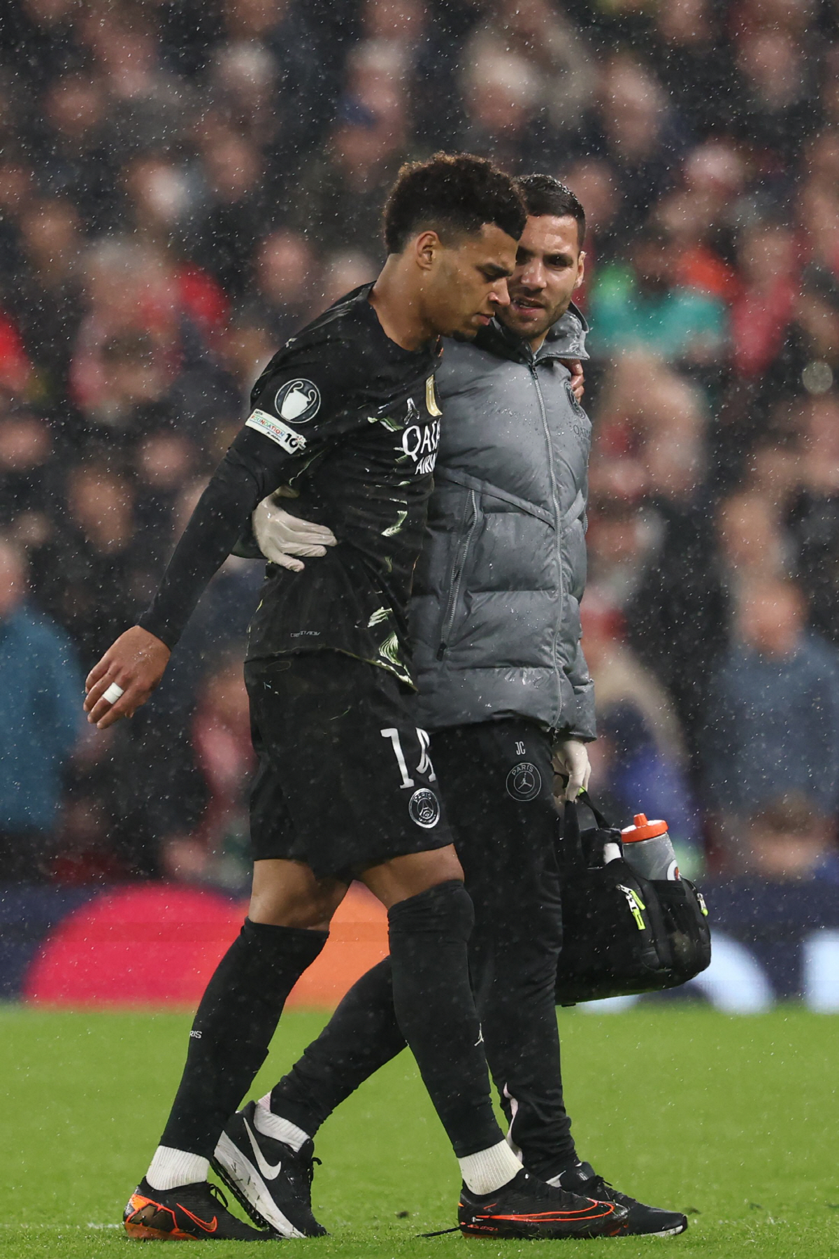 Paris Saint-Germain's French midfielder #14 Desire Doue is helped from the pitch after hurting himself as he collided with the microphone stand during the UEFA Champions League quarter final, second-leg football match between Liverpool and Paris Saint-Germain at Anfield in Liverpool, north west England on April 14, 2026. (Photo by FRANCK FIFE / AFP)