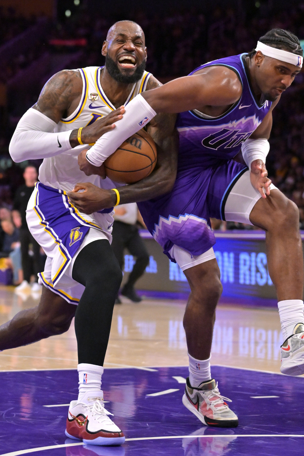Los Angeles Lakers forward LeBron James, left, is fouled by Utah Jazz forward Blake Hinson, right, as he drives to the basket during the first half of an NBA basketball game Sunday, April 12, 2026, in Los Angeles. (AP Photo/Jayne Kamin-Oncea)