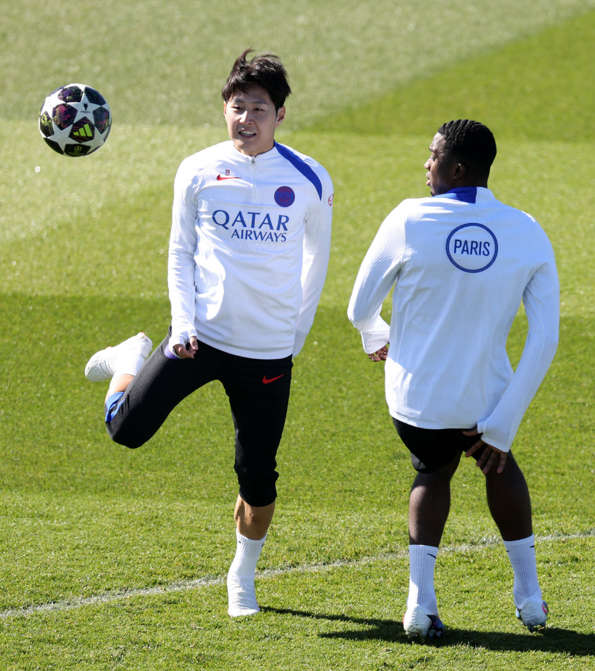 Paris Saint-Germain's South Korean midfielder #19 Lee Kang-in (L) and Paris Saint-Germain's French defender #51 William Pacho take part in a training session at the Campus Paris Saint-Germain in Poissy, on the western outskirts of Paris on April 7, 2026, on the eve of the UEFA Champions League quarter-final first leg football match against Liverpool F.C. (Photo by FRANCK FIFE / AFP)