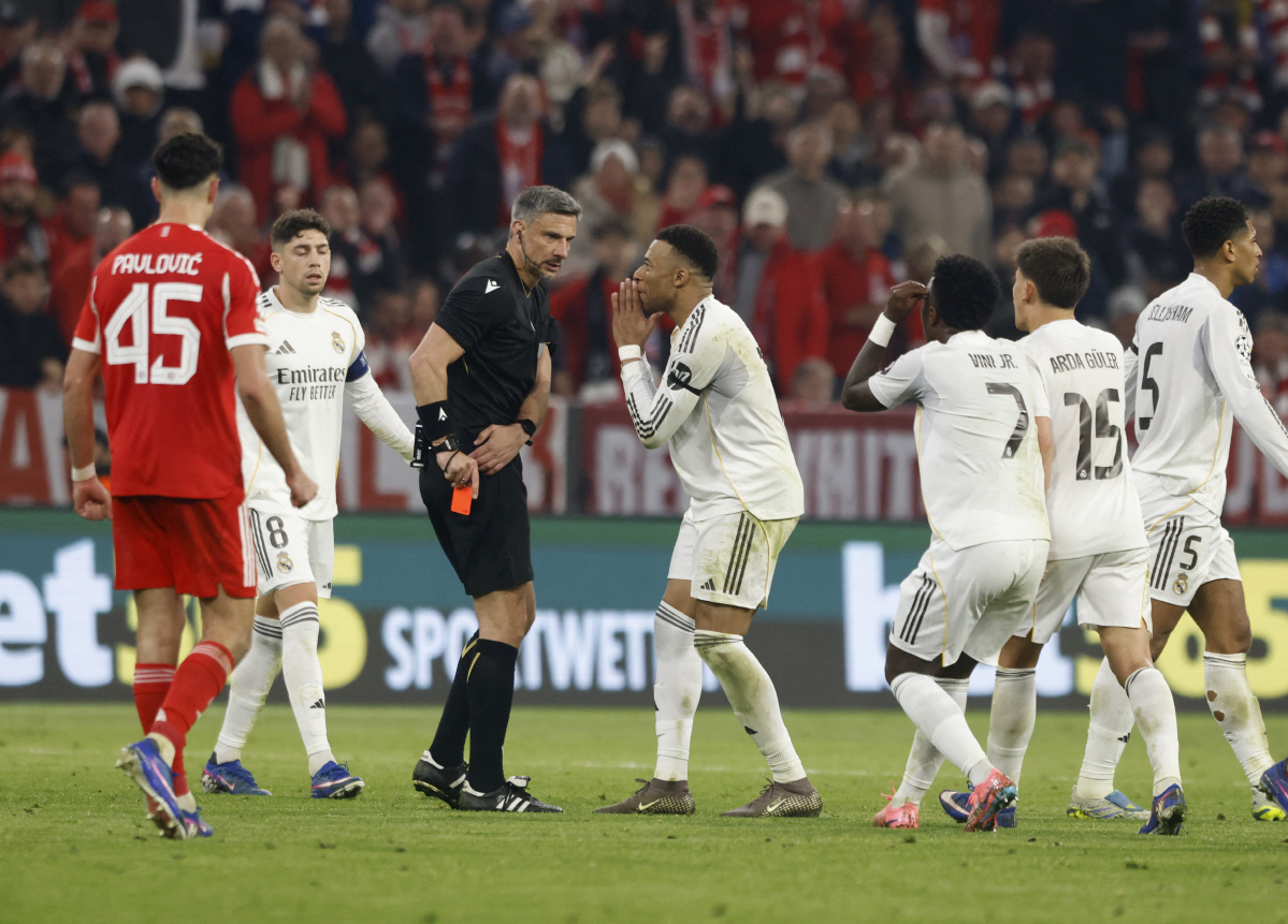 Soccer Football - UEFA Champions League - Quarter Final - Second Leg - Bayern Munich v Real Madrid - Allianz Arena, Munich, Germany - April 15, 2026 Real Madrid's Kylian Mbappe, Vinicius Junior and Arda Guler remonstrate with referee Slavko Vincic after Real Madrid's Eduardo Camavinga was shown a red card REUTERS/Michaela Stache
