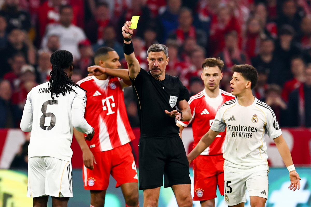 epa12892614 Referee Slavko Vincic (C) shows yellow card to Eduardo Camavinga (L) of Real Madrid during the UEFA Champions League quarter-finals, 2nd leg match FC Bayern Munich against Real Madrid, in Munich, Germany, 15 April 2026. EPA/ANNA SZILAGYI