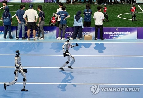 (베이징=연합뉴스) 정성조 특파원 = 15일 중국 베이징 국가스피드스케이팅홀에서 열린 '세계 휴머노이드 로봇 운동회'에 참가한 로봇들이 달리기 경기를 하고 있다. 2025.8.15 xing@yna.co.kr