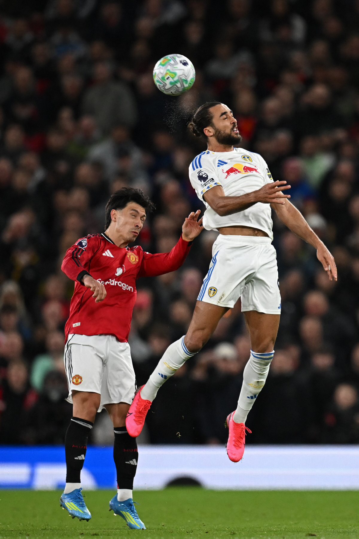 Leeds United's English striker #09 Dominic Calvert-Lewin (R) vies with Manchester United's Argentinian defender #06 Lisandro Martinez (L) during the English Premier League football match between Manchester United and Leeds United at Old Trafford in Manchester, north west England, on April 13, 2026. (Photo by Paul ELLIS / AFP) / RESTRICTED TO EDITORIAL USE. No use with unauthorized audio, video, data, fixture lists, club/league logos or 'live' services. Online in-match use limited to 120 images. An additional 40 images may be used in extra time. No video emulation. Social media in-match use limited to 120 images. An additional 40 images may be used in extra time. No use in betting publications, games or single club/league/player publications. /