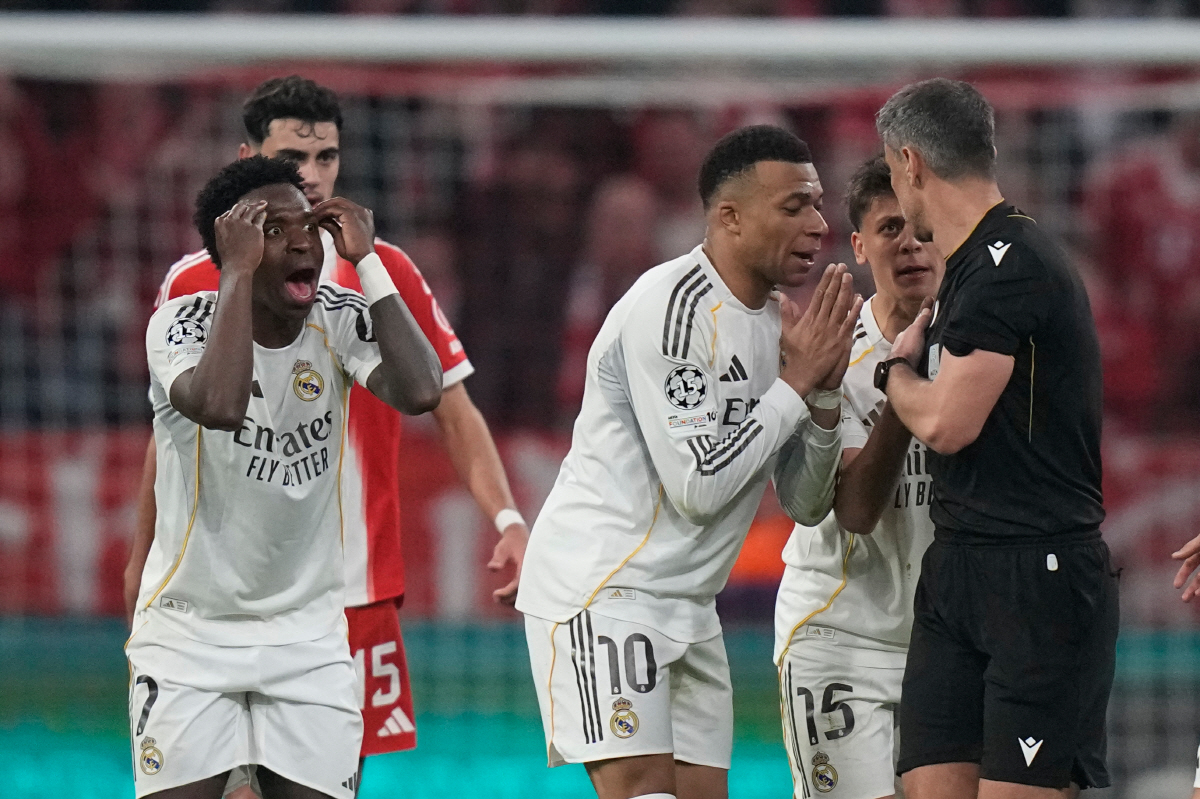 Real Madrid's Kylian Mbappe, center, and Vinicius Jr., left, disagree with referee Slavko Vincic during the Champions League quarterfinal second leg soccer match between Bayern Munich and Real Madrid in Munich, Germany, Wednesday, April 15, 2026. (AP Photo/Matthias Schrader)