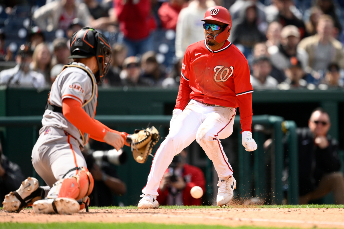 Washington Nationals' Nasim Nunez, right, runs home to score against San Francisco Giants catcher Patrick Bailey, left, on a double by Keibert Ruiz during the fifth inning of a baseball game Sunday, April 19, 2026, in Washington. (AP Photo/Nick Wass)