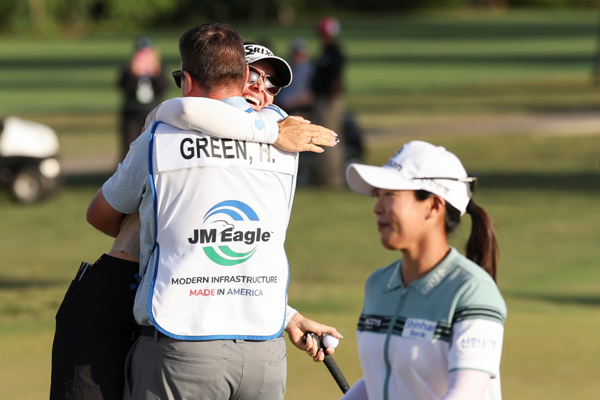 Hannah Green and her caddie David Buhai, back left, embrace as Jin Hee Im, front right, looks on after Green wins the LPGA JM Eagle LA Championship golf tournament at El Caballero Country Club Sunday, April 19, 2026, in Los Angeles. (AP Photo/Jessie Alcheh)