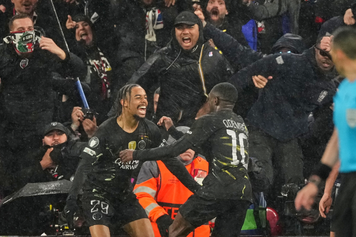 PSG's Ousmane Dembele, right, celebrates with Bradley Barcola after scoring his side's second goal during the Champions League quarterfinal second leg soccer match between Liverpool and Paris Saint-Germain in Liverpool, England, Tuesday, April 14, 2026. (AP Photo/Dave Shopland)