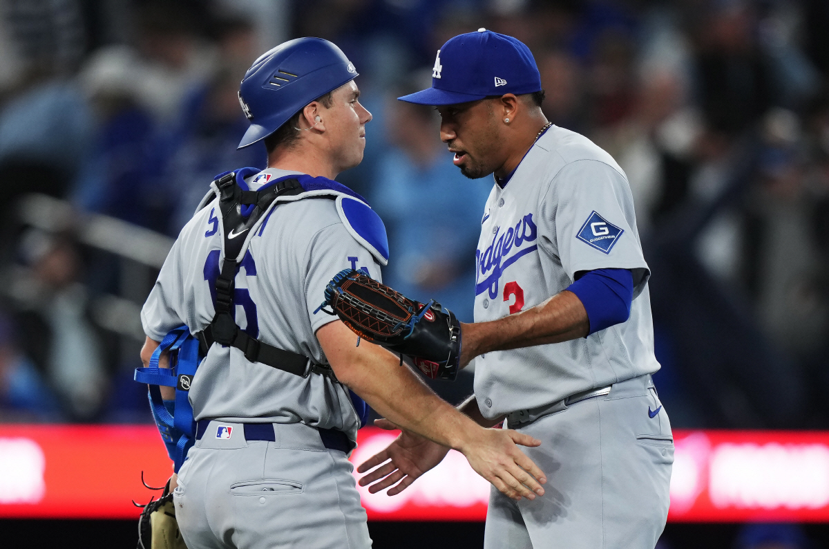 Los Angeles Dodgers catcher Will Smith (16) and pitcher Edwin Diaz (3) celebrate after defeating the Toronto Blue Jays in an MLB baseball game in Toronto on Tuesday, April 7, 2026. (Nathan Denette/The Canadian Press via AP) MANDATORY CREDIT