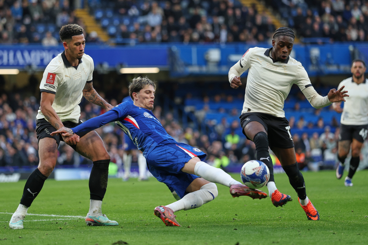 Chelsea's Alejandro Garnacho, centre, challenges for the ball with Port Vale's Jordan Lawrence-Gabriel, left, and Port Vale's Ethon Archer during the English FA Cup quarterfinal soccer match between Chelsea and Port Vale in London, England, Saturday, April 4, 2026. (AP Photo/Ian Walton)