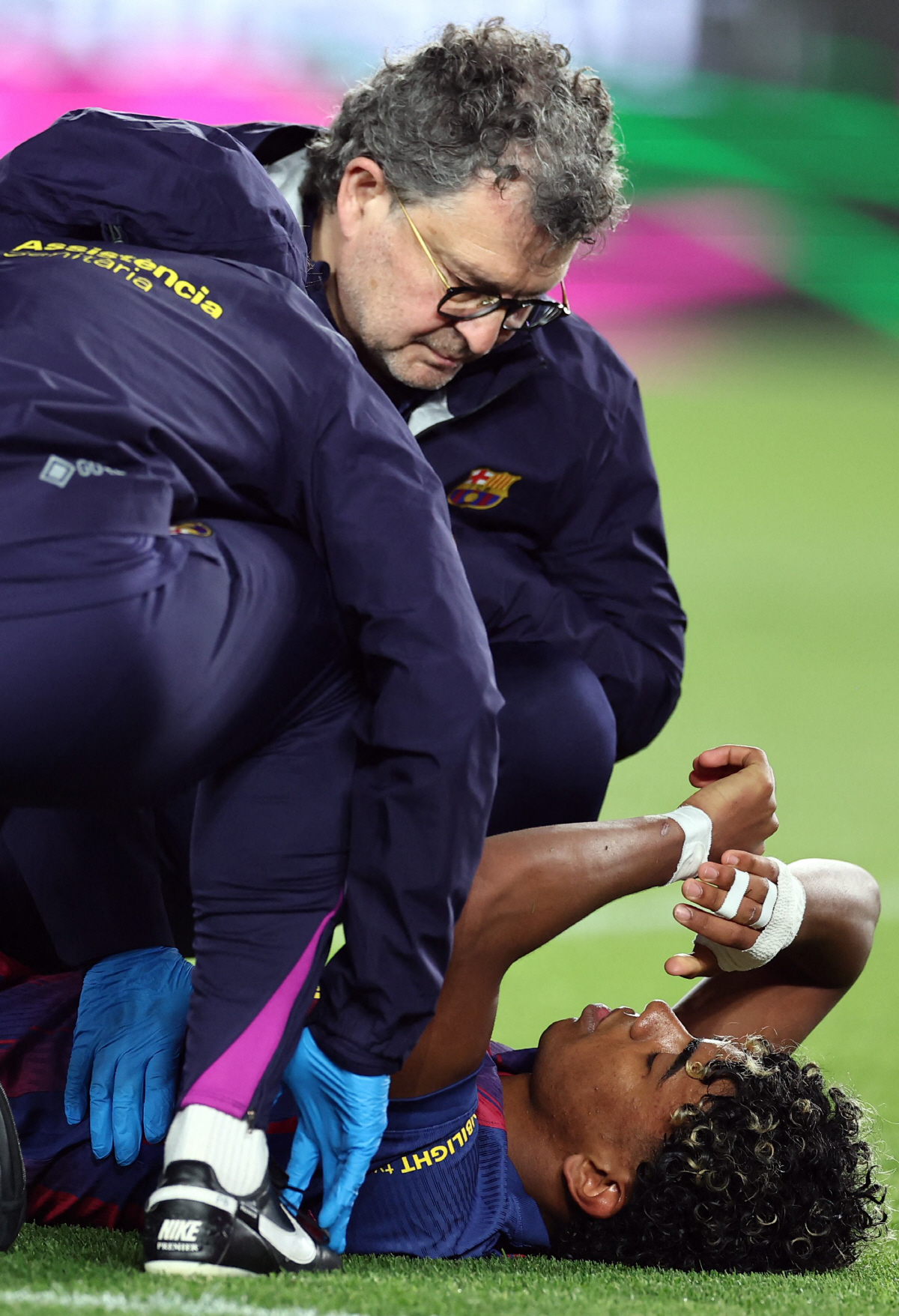 Barcelona's Spanish forward #10 Lamine Yamal receives medical attention after sustaining an injury during the Spanish league football match between FC Barcelona and RC Celta de Vigo at Camp Nou stadium in Barcelona on April 22 , 2026. (Photo by Josep LAGO / AFP)