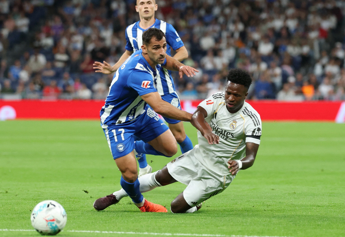 Real Madrid's Brazilian forward #07 Vinicius Junior falls while fighting for the ball with Alaves' Spanish defender #17 Jonny Castro during the Spanish league football match between Real Madrid CF and Deportivo Alaves at the Santiago Bernabeu stadium in Madrid on April 21, 2026. (Photo by Pierre-Philippe MARCOU / AFP)