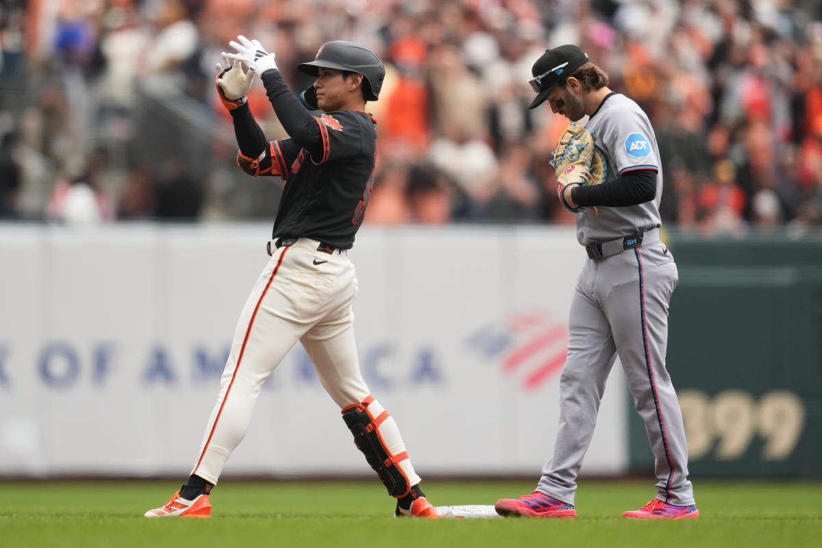 San Francisco Giants' Jung Hoo Lee, left, reacts after hitting a double next to Miami Marlins first baseman Connor Norby during the second inning of a baseball game Saturday, April 25, 2026, in San Francisco. (AP Photo/Jeff Chiu)