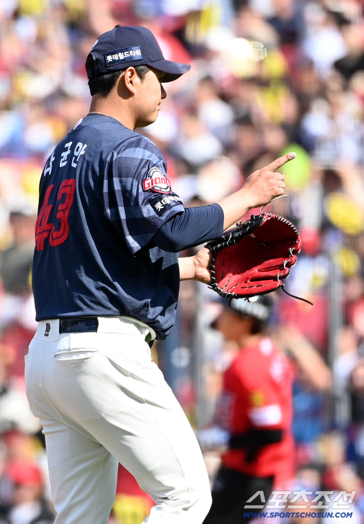 나균안이 5회까지 리드를 지킨 뒤 포수 손성빈에게 손짓하는 장면