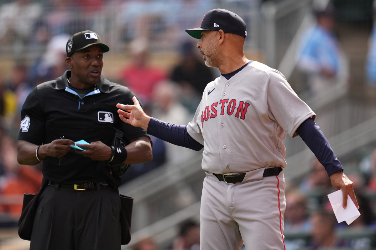 Boston Red Sox manager Alex Cora (13) talks with home plate umpire Malachi Moore during the eighth inning of a baseball game against the Minnesota Twins, Wednesday, April 15, 2026, in Minneapolis. (AP Photo/Abbie Parr)