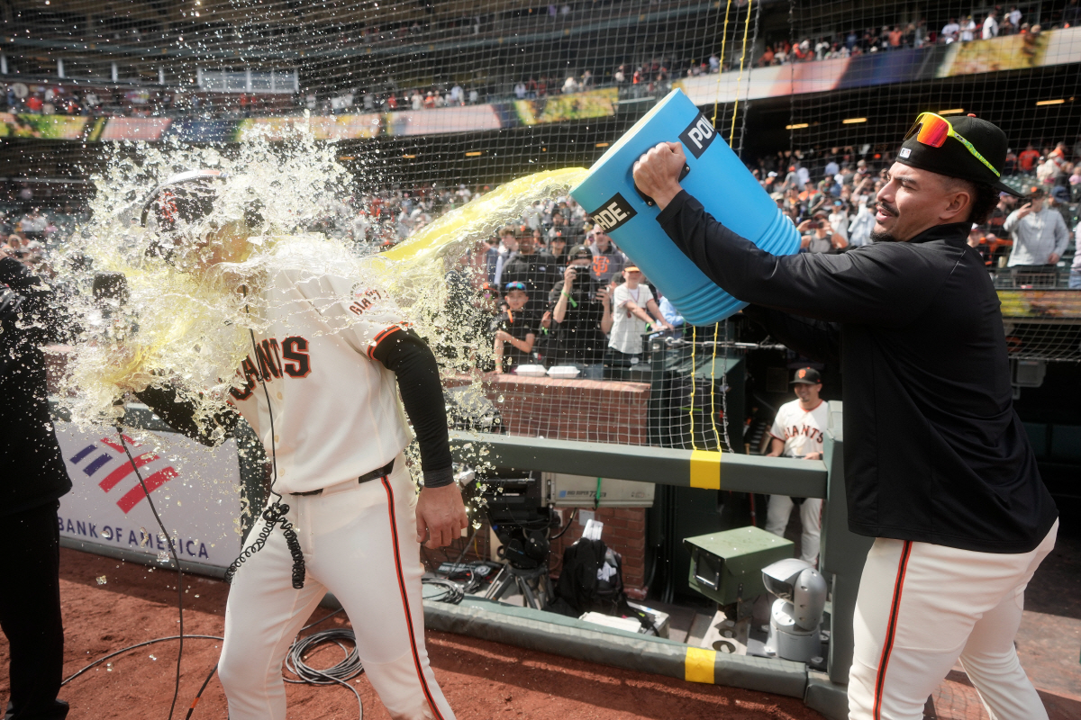 San Francisco Giants' Jung Hoo Lee, left, is doused by Willy Adames while being interviewed after a baseball game against the Miami Marlins Sunday, April 26, 2026, in San Francisco. (AP Photo/Jeff Chiu)