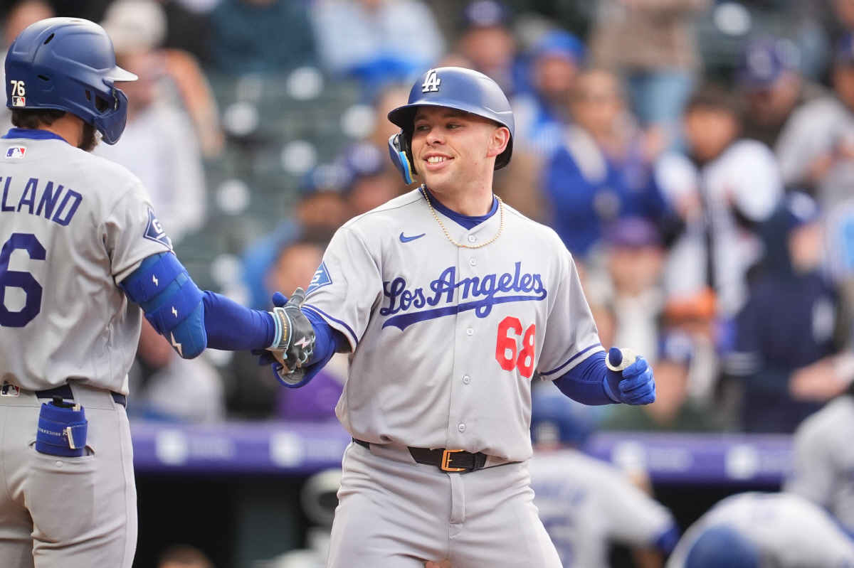 Los Angeles Dodgers' Dalton Rushing, right, is congratulated as he crosses home plate by Alex Freeland after hitting a solo home run off Colorado Rockies starting pitcher Ryan Feltner in the second inning of a baseball game Saturday, April 18, 2026, in Denver. (AP Photo/David Zalubowski)