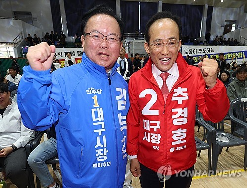 (대구=연합뉴스) 김현태 기자 = 1일 대구 북구 대구복합스포츠타운 시민체육관에서 열린 한국노총 노동절 기념대회에서 더불어민주당 김부겸 대구시장 예비후보(왼쪽)와 국민의힘 추경호 대구시장 예비후보가 파이팅을 외치고 있다. 2026.5.1 mtkht@yna.co.kr