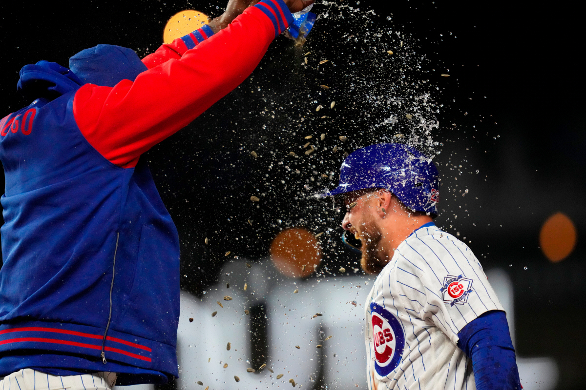 Chicago Cubs' Michael Busch (29) is doused with water and sunflower seeds after Cincinnati Reds pitcher Brock Burke (49) threw him four balls and forced in a run to win the baseball game Wednesday, May 6, 2026, in Chicago. (AP Photo/Erin Hooley)