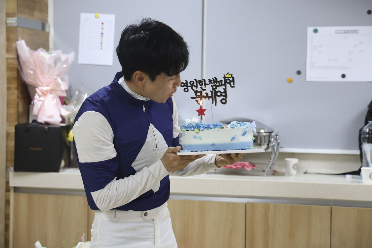 문세영 기수가 동료 기수들이 준비한 케이크 촛불을 불고 있다. 사진제공=한국마사회