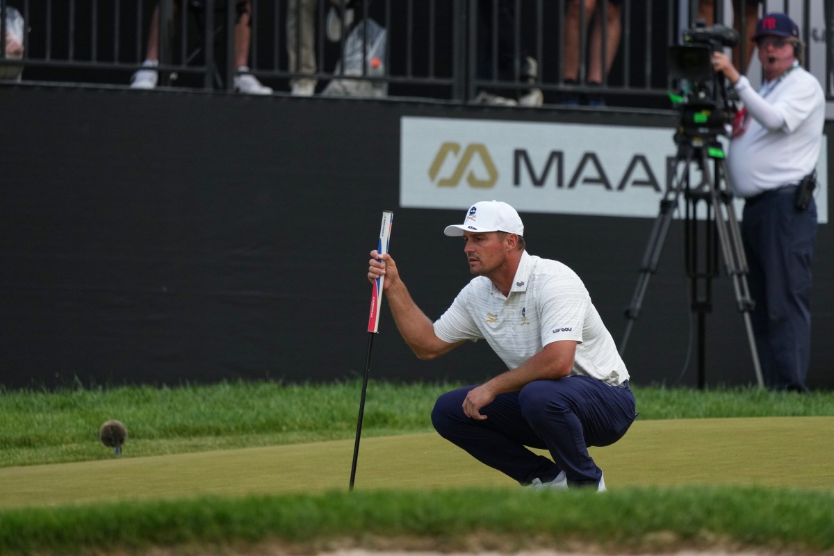 Bryson DeChambeau lines up his putt on the 18th green during the Maaden LIV Golf Virginia tournament at Trump National Golf Club, Saturday, May 9, 2026, in Sterling, Va. (AP Photo/Alex Brandon)