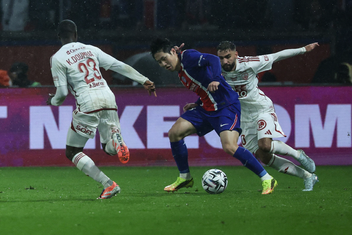 Paris Saint-Germain's South Korean midfielder #19 Lee Kang-in dribbles past Brest's French forward #10 Romain Del Castillo (R) and Brest's Malian midfielder #23 Kamory Doumbia during the French L1 football match between Paris Saint-Germain (PSG) and Stade Brestois 29 (Brest) at the Parc des Princes stadium in Paris on May 10, 2026. (Photo by Xavier GALIANA / AFP)