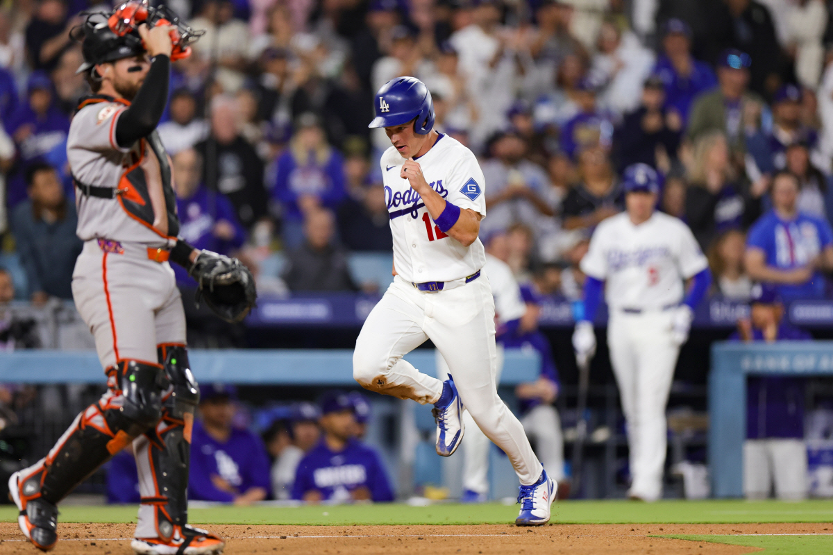 Los Angeles Dodgers' Alex Call, right, runs past San Francisco Giants catcher Eric Haase to score off of a single hit by Miguel Rojas during the sixth inning of a baseball game Thursday, May 14, 2026, in Los Angeles. (AP Photo/Ryan Sun)