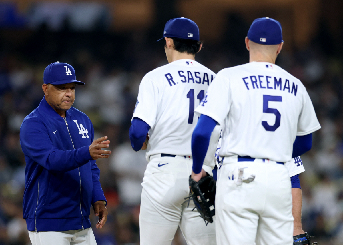 LOS ANGELES, CALIFORNIA - MAY 11: Dave Roberts #30 of the Los Angeles Dodgers comes to the mound to take out Roki Sasaki #11 from the game in front of Freddie Freeman #5 during the sixth inning at Dodger Stadium on May 11, 2026 in Los Angeles, California. Harry How/Getty Images/AFP (Photo by Harry How / GETTY IMAGES NORTH AMERICA / Getty Images via AFP)