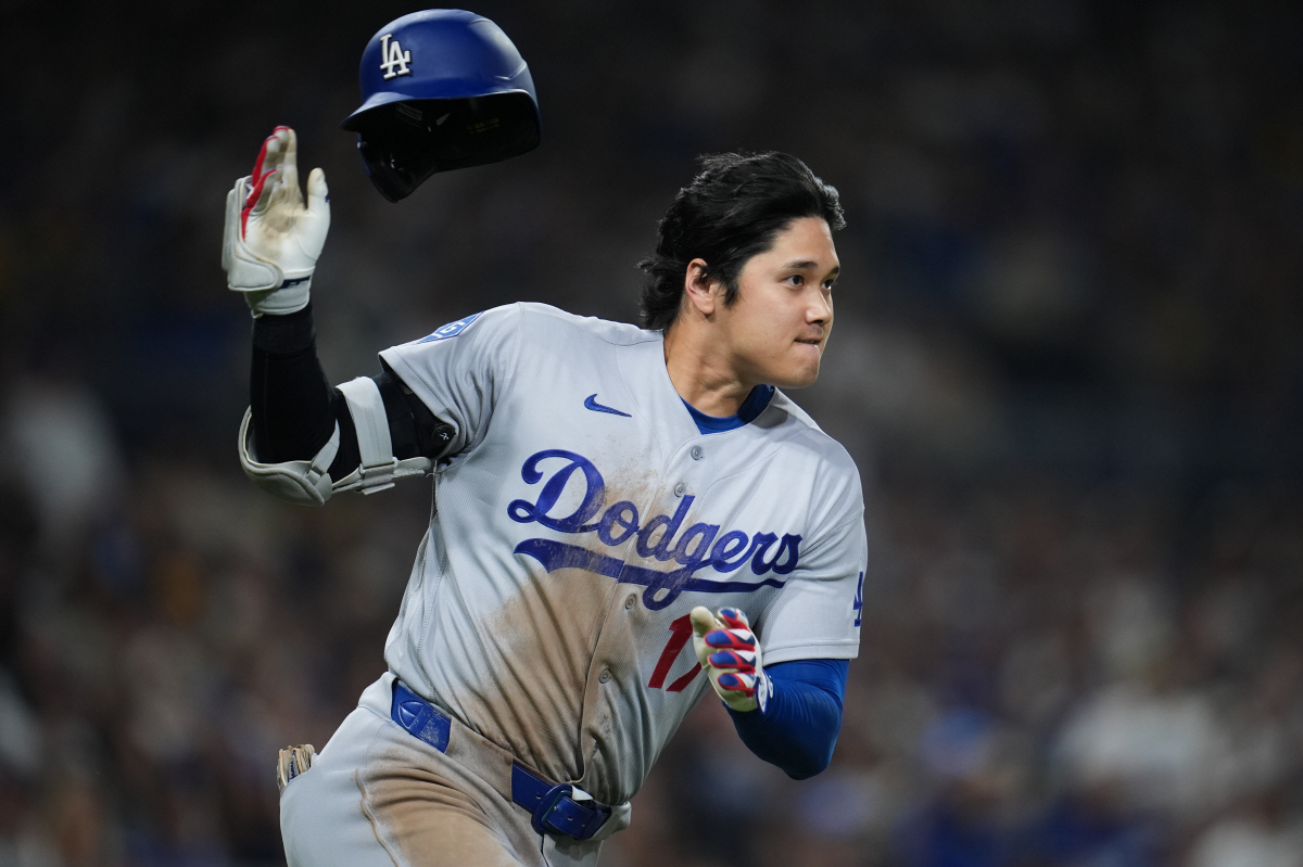Los Angeles Dodgers' Shohei Ohtani throws off his helmet as he rounds first base after hitting a double during the eighth inning of a baseball game against the San Diego Padres Tuesday, May 19, 2026, in San Diego. (AP Photo/Gregory Bull)