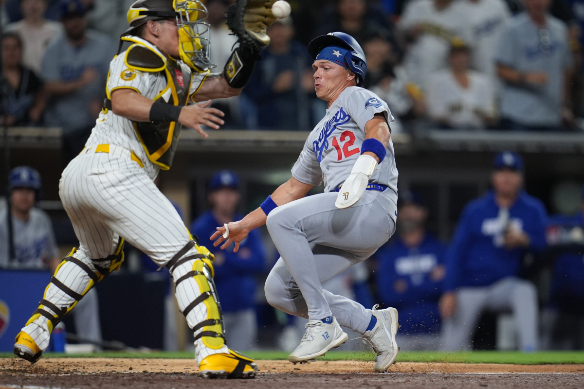 Los Angeles Dodgers' Alex Call, right, scores from third off a sacrifice fly by Andy Pages as San Diego Padres catcher Freddy Fermin is late with the catch during the ninth inning of a baseball game Tuesday, May 19, 2026, in San Diego. (AP Photo/Gregory Bull)