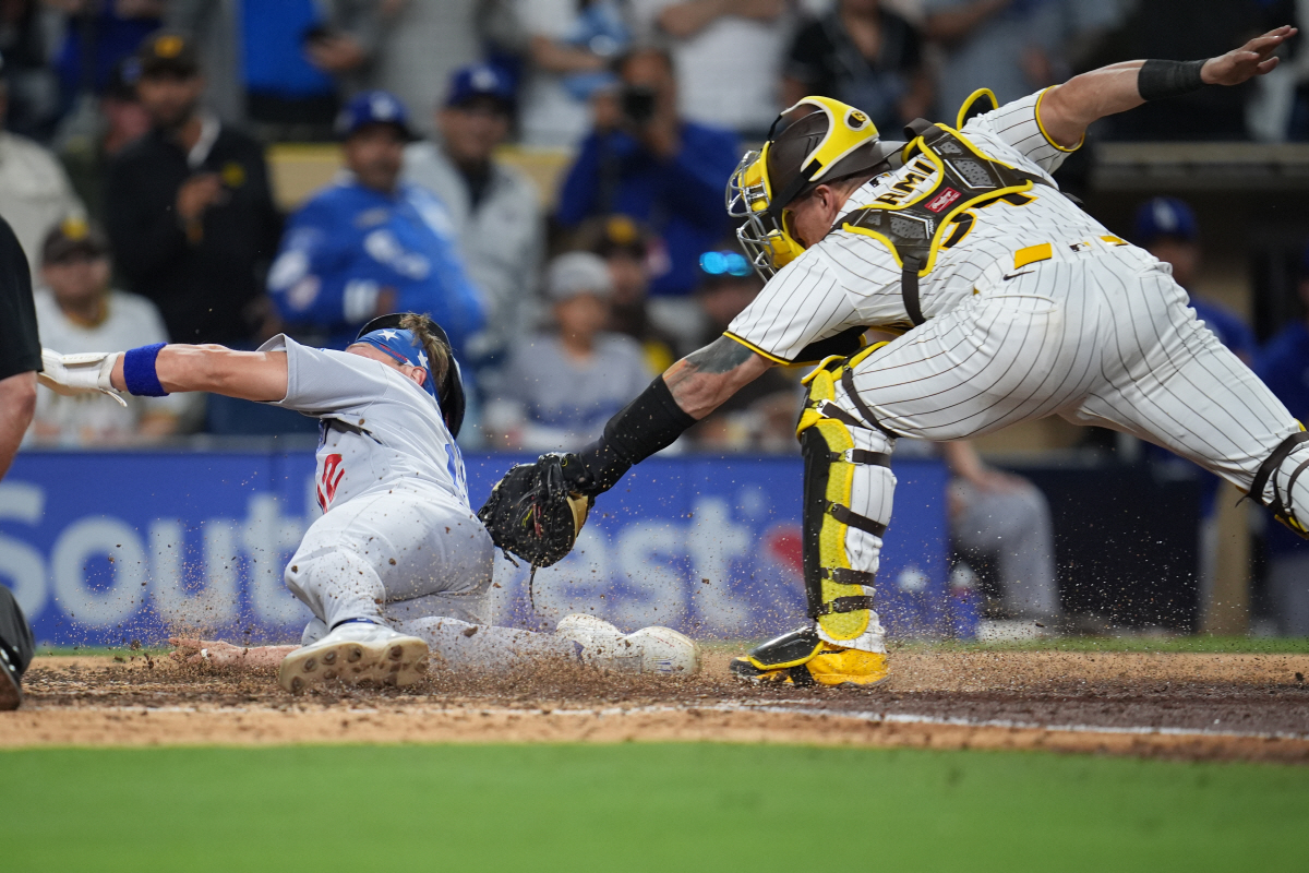 Los Angeles Dodgers' Alex Call, left, scores from third off a sacrifice fly by Andy Pages as San Diego Padres catcher Freddy Fermin is late with the tag during the ninth inning of a baseball game Tuesday, May 19, 2026, in San Diego. (AP Photo/Gregory Bull)