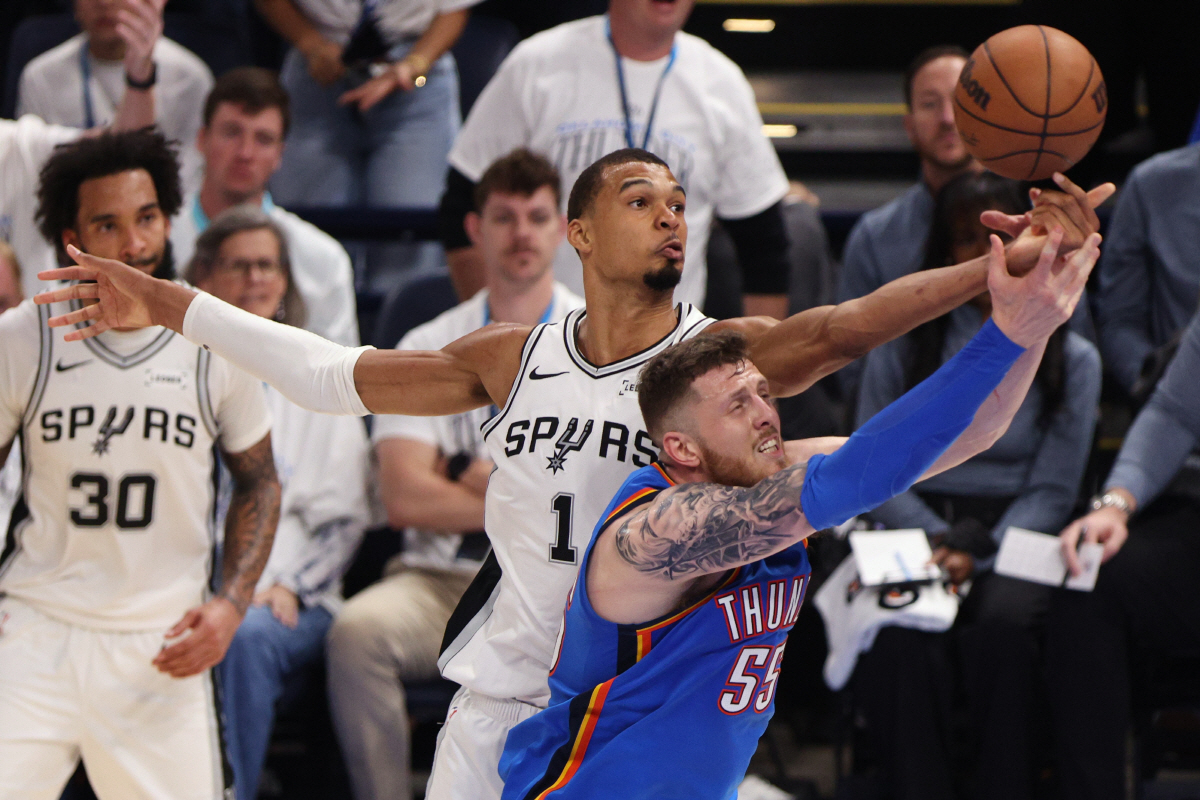San Antonio Spurs forward Victor Wembanyama (1) and Oklahoma City Thunder center Isaiah Hartenstein (55) reach for the ball during the second half of Game 2 in the Western Conference finals NBA basketball playoffs series Wednesday, May 20, 2026, in Oklahoma City. (AP Photo/Nate Billings)