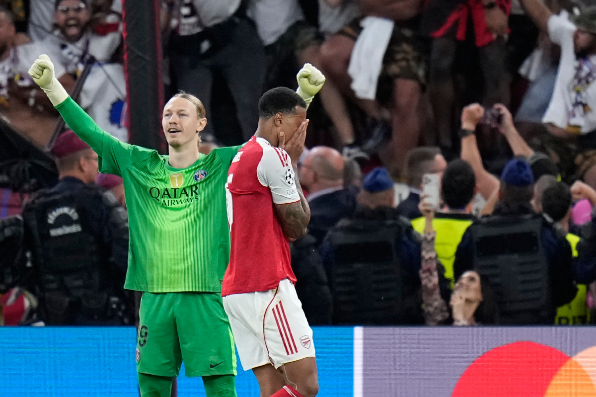 PSG's goalkeeper Matvey Safonov, left, celebrates while Arsenal's Gabriel Magalhaes, right, reacts after failing to score during a penalty shootout after extra time during the Champions League final soccer match between Paris Saint-Germain and Arsenal in Budapest, Hungary, Saturday, May 30, 2026. (AP Photo/Petr Josek)