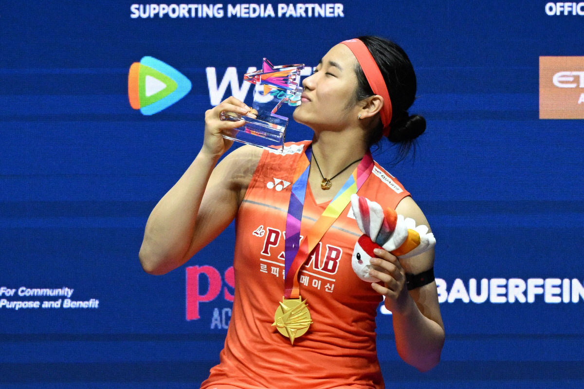 An Se-young of South Korea celebrates with the trophy after defeating Akane Yamaguchi of Japan in the women?s singles final match of the KFF Singapore Open Badminton tournament in Singapore on May 31, 2026. (Photo by Roslan RAHMAN / AFP)