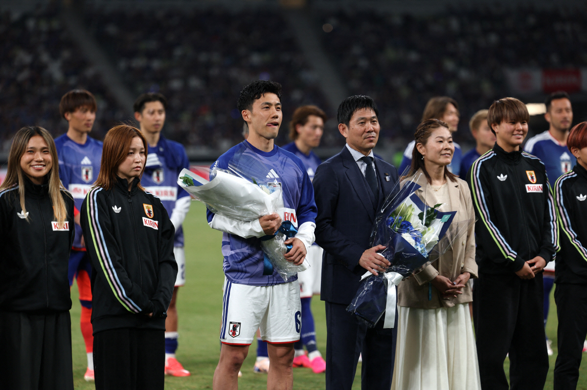 Soccer Football - International Friendly - Japan v Iceland - National Stadium, Tokyo, Japan - May 31, 2026 Japan's Wataru Endo and coach Hajime Moriyasu poses for a picture with members of the Japan women's national team and former Japan player Homare Sawa after the match during the send-off ahead of the World Cup REUTERS/Issei Kato