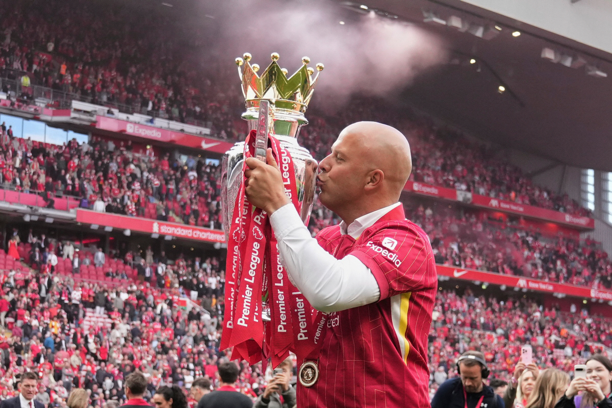 FILE - Liverpool's manager Arne Slot kisses the winner's trophy as he celebrates after the English Premier League soccer match between Liverpool and Crystal Palace at the Anfield stadium in Liverpool, England, Sunday, May 25, 2025. (AP Photo/Jon Super, File) FILE