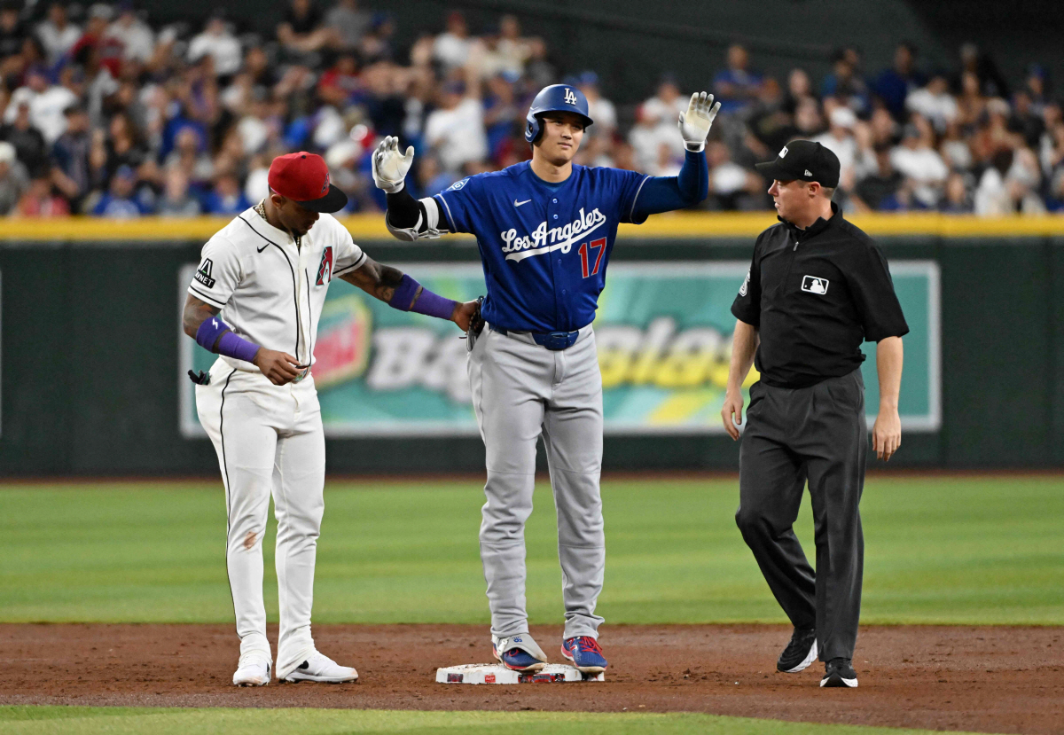 PHOENIX, ARIZONA - JUNE 01: Shohei Ohtani #17 of the Los Angeles Dodgers gestures to his dugout after hitting a double as Ketel Marte #4 of the Arizona Diamondbacks tags him during the third inning at Chase Field on June 01, 2026 in Phoenix, Arizona. Norm Hall/Getty Images/AFP (Photo by Norm Hall / GETTY IMAGES NORTH AMERICA / Getty Images via AFP)