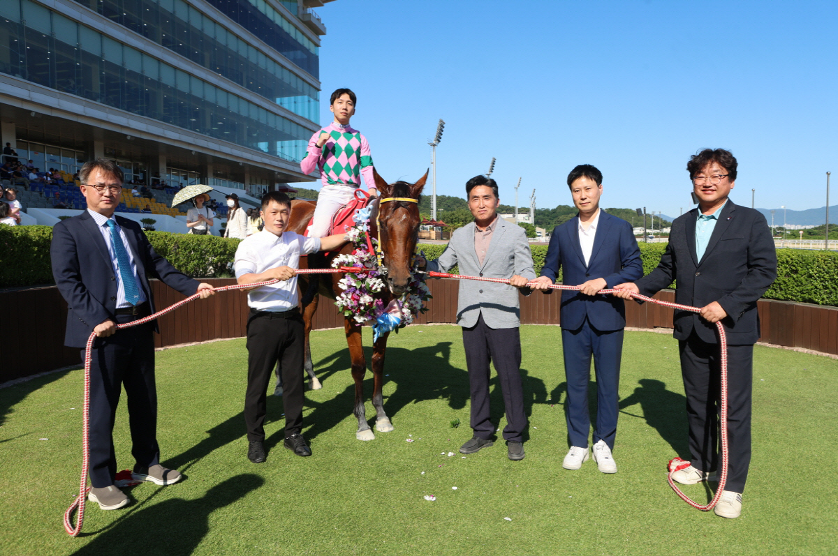 제19회 KNN배 대상경주 우승 세리머니 후 엄영석 한국마사회 영남지역본부장과 최동수 마필관리사, 이효식 기수, 강은석 조교사, 양진호 마주, 김백수 KNN 상무(이상 왼쪽부터)가 기념 촬영을 하고 있다. 사진제공=한국마사회