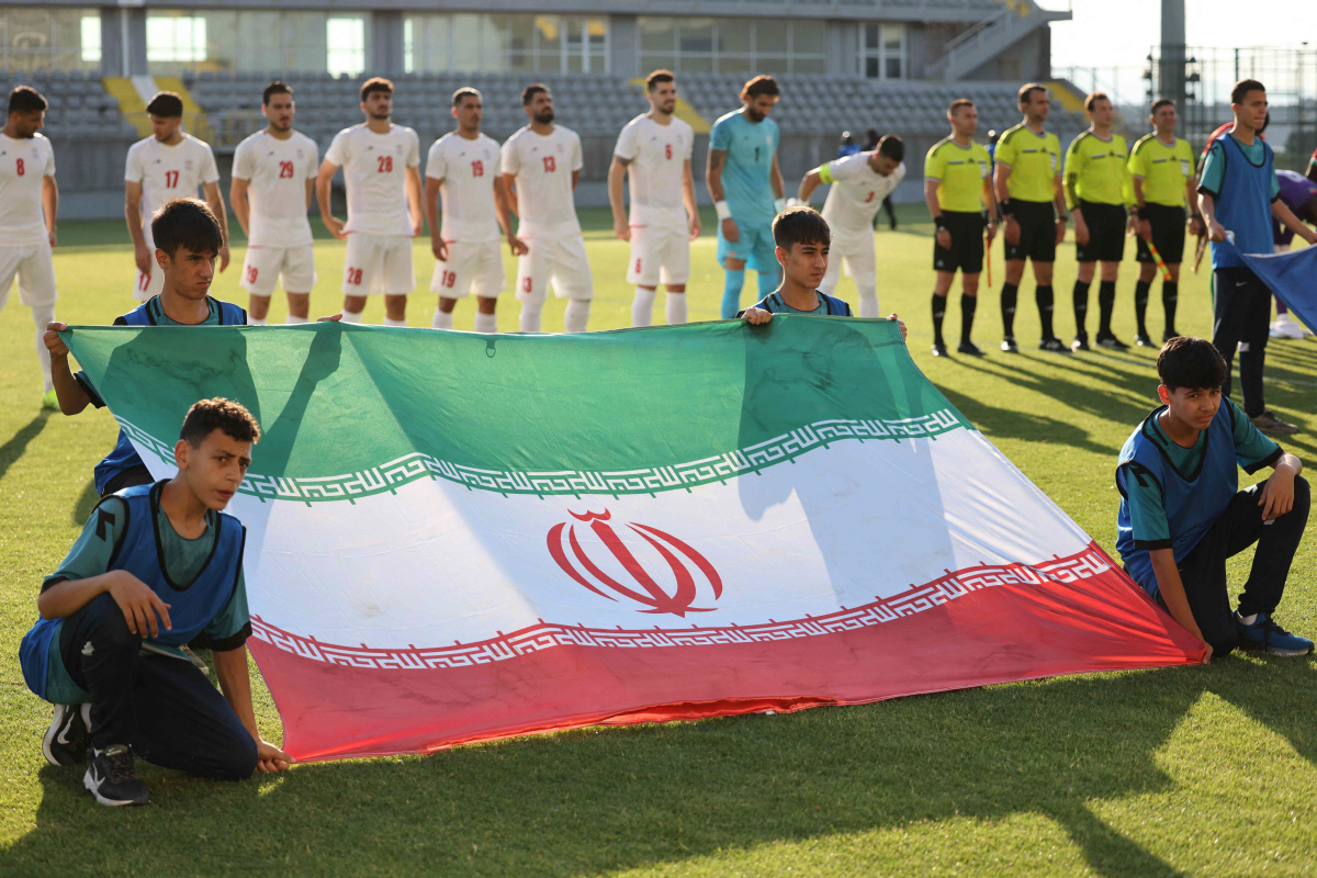 Iran's players stand behind the flag of Iran for photographers before the start of an international friendly football match between Iran and Gambia, in Antalya, southern Turkey, on May 29, 2026, as part of the team's preparation for the upcoming football World Cup. (Photo by Oner SAN / AFP)