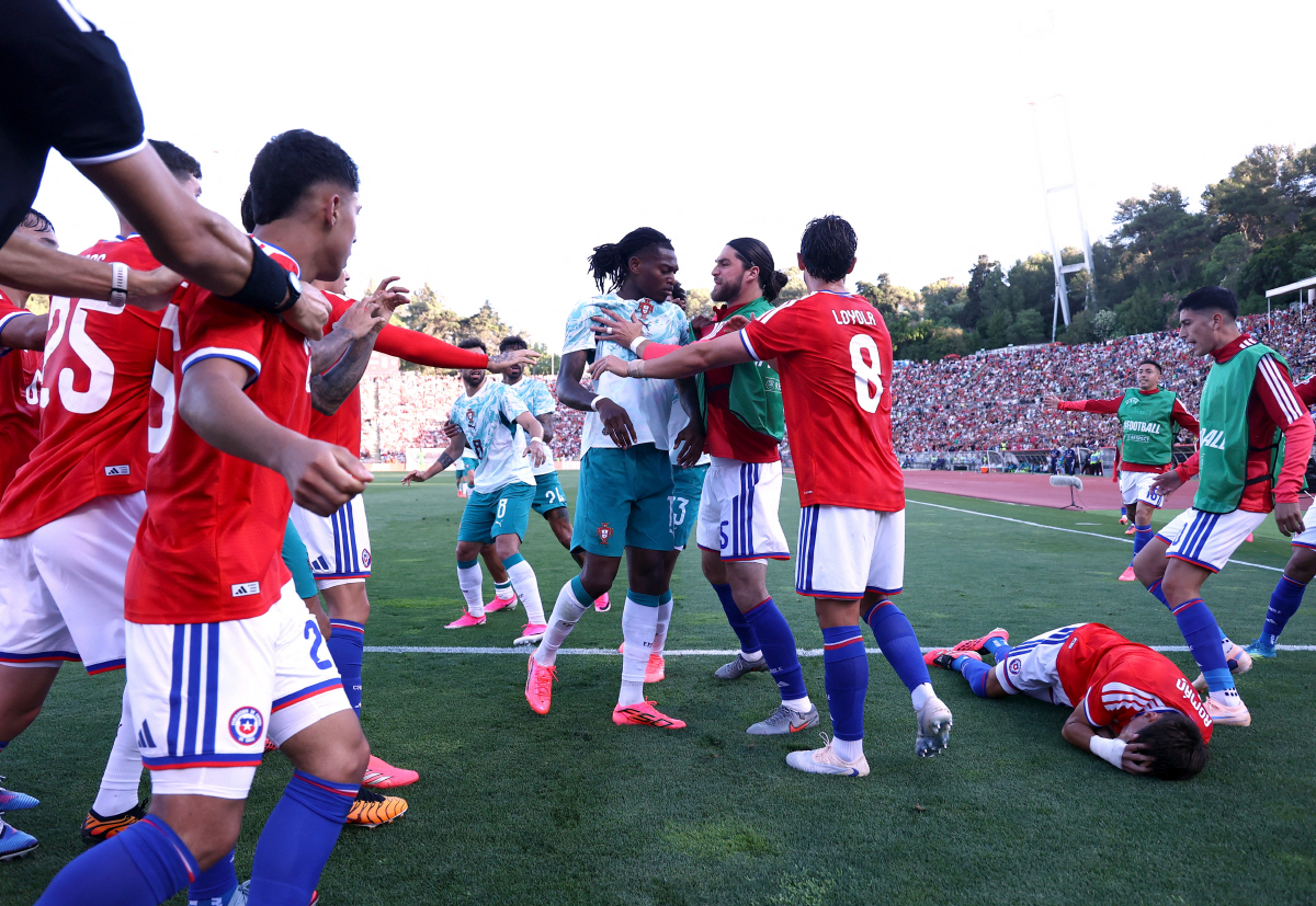 Soccer Football - International Friendly - Portugal v Chile - Estadio Nacional do Jamor, Lisbon, Portugal - June 6, 2026 Portugal's Rafael Leao and Chile's Francisco Sierralta clash as Ivan Roman reacts REUTERS/Rodrigo Antunes
