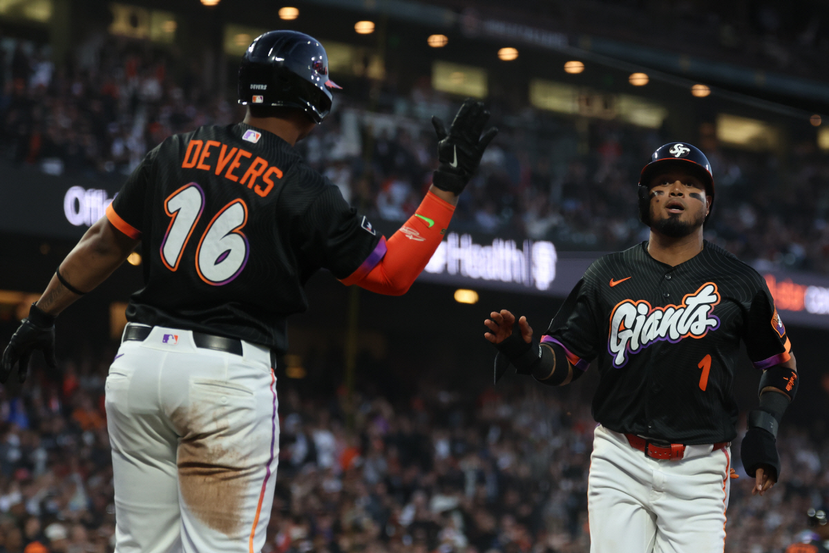 San Francisco Giants' Luis Arraez (1) is congratulated by Rafael Devers (16) after scoring on a double hit by Jung Hoo Lee during the fifth inning of a baseball game against the Washington Nationals in San Francisco, Tuesday, June 9, 2026. (AP Photo/Jed Jacobsohn)