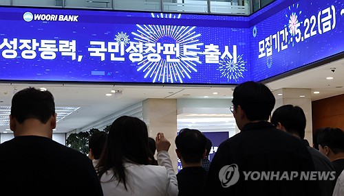 (서울=연합뉴스) 이진욱 기자 = 오는 22일부터 주요 시중은행들은 국민참여형 국민성장펀드를 선착순으로 판매한다. 국민참여성장펀드는 금융위원회 주관으로 첨단전략산업 육성을 위해 조성된 '국민성장펀드'에 일반 국민도 투자 참여할 수 있도록 만들어진 상품이다. 사진은 21일 서울 중구 우리은행 본점 로비 스크린에 관련 안내문이 나오는 모습. 2026.5.21 cityboy@yna.co.kr