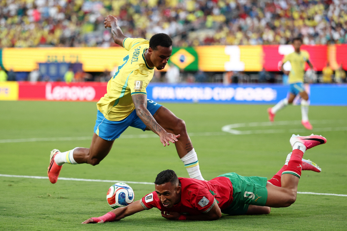 Morocco's forward #09 Soufiane Rahimi (R) falls on the ground past Brazil's defender #03 Gabriel Magalhaes during the 2026 World Cup Group C football match between Brazil and Morocco at the New York/New Jersey Stadium in East Rutherford on June 13, 2026. (Photo by CHARLY TRIBALLEAU / AFP)