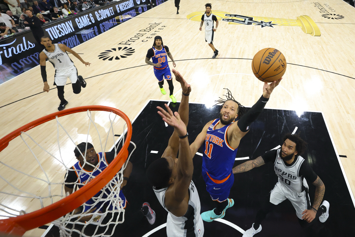 Jun 13, 2026; San Antonio, Texas, USA; New York Knicks guard Jalen Brunson (11) drives to the basket past San Antonio Spurs forward Julian Champagnie (30) during game five of the 2026 NBA Finals at Frost Bank Center. Mandatory Credit: Geoff Burke-Pool Photo via Imagn Images