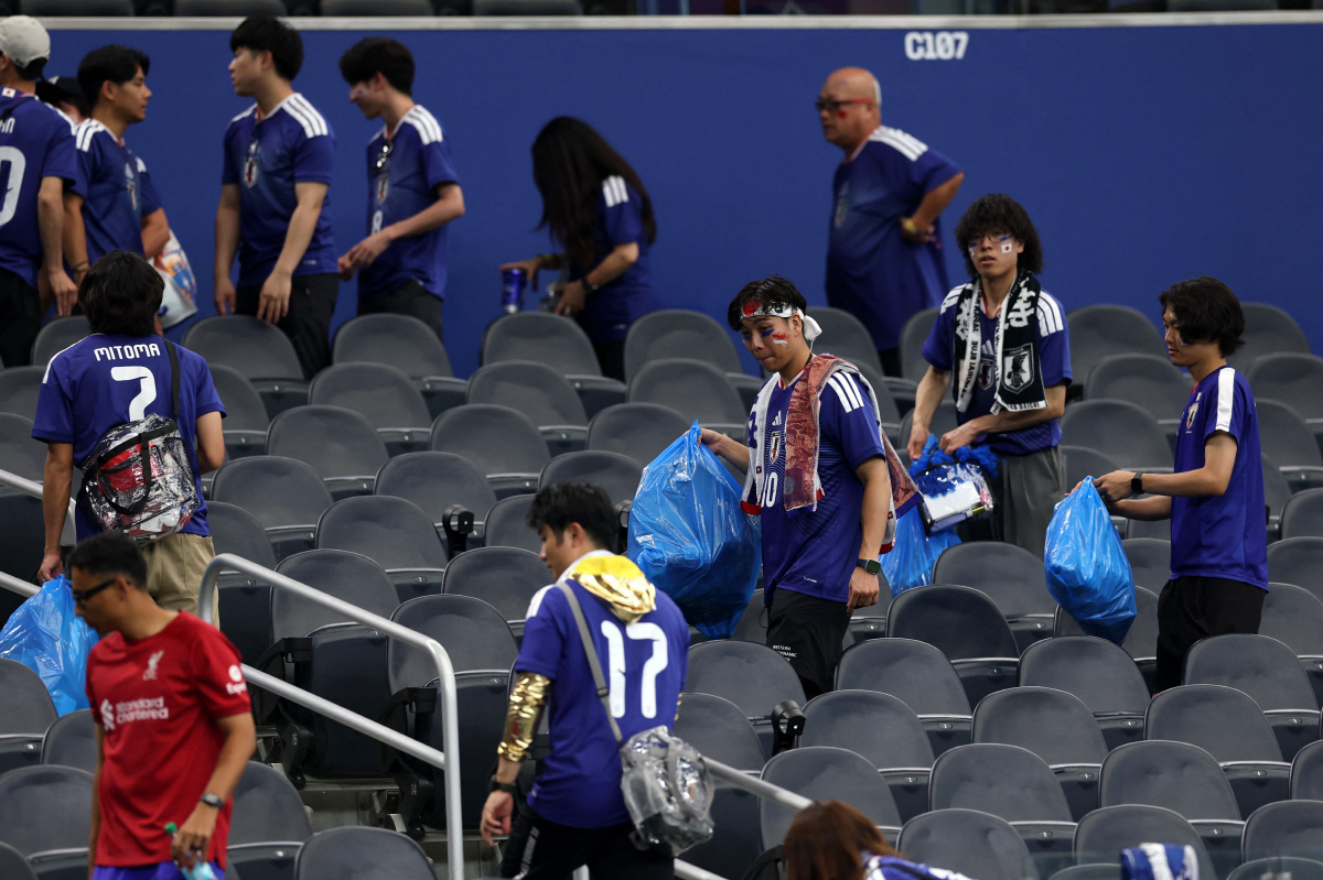 경기 종료 후 쓰레기를 치우고 있는 일본 축구팬들 AFP